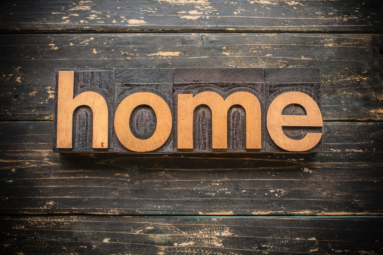 Home Concept Vintage Wooden Letterpress Type Word The word "HOME" written in vintage wood letterpress type on a vintage rustic background.