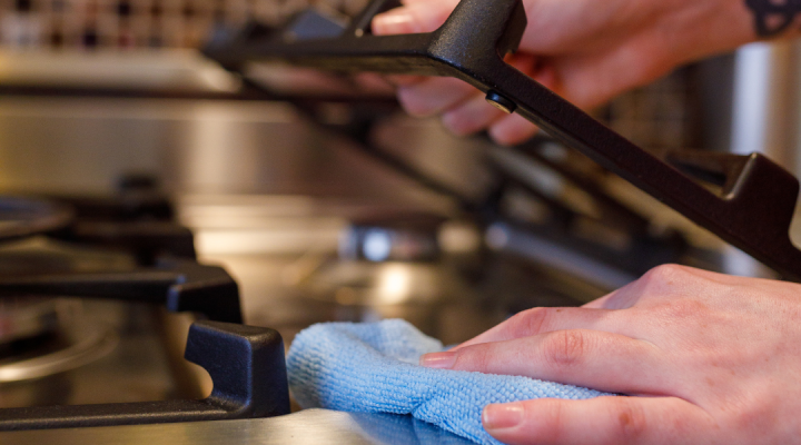 cleaning stovetop with towel